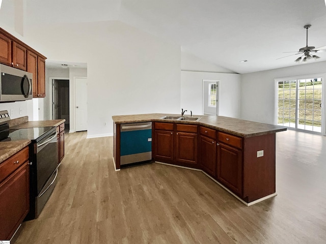 kitchen featuring lofted ceiling, a kitchen island with sink, hardwood / wood-style flooring, and appliances with stainless steel finishes