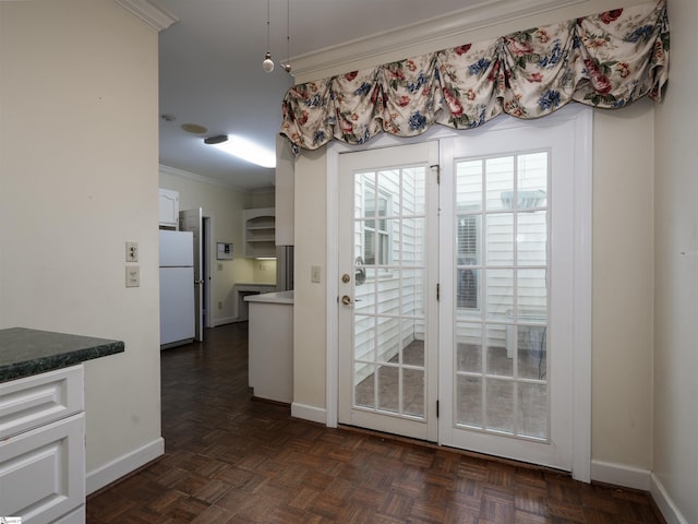 entryway with dark parquet flooring and crown molding