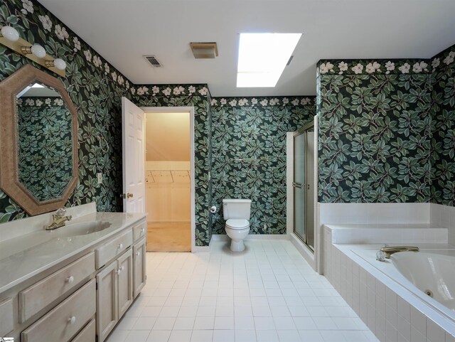 bathroom with a skylight, tile patterned floors, walk in shower, vanity, and toilet