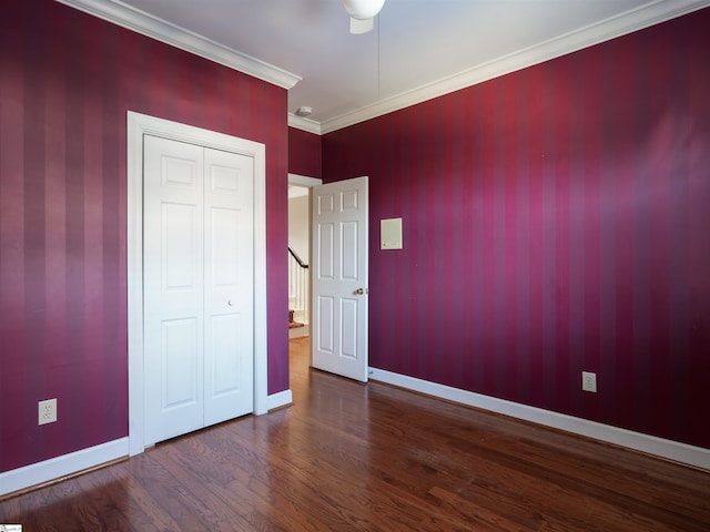 unfurnished bedroom featuring wood-type flooring, a closet, ceiling fan, and ornamental molding