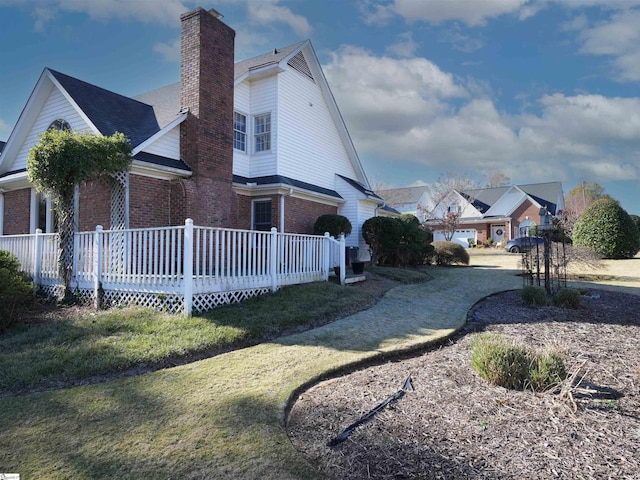 view of side of property with a lawn and a wooden deck