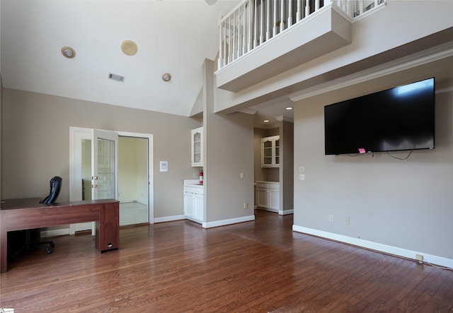 unfurnished office featuring french doors, high vaulted ceiling, and dark wood-type flooring