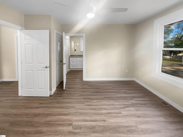 interior space with ensuite bathroom, ceiling fan, and light hardwood / wood-style flooring