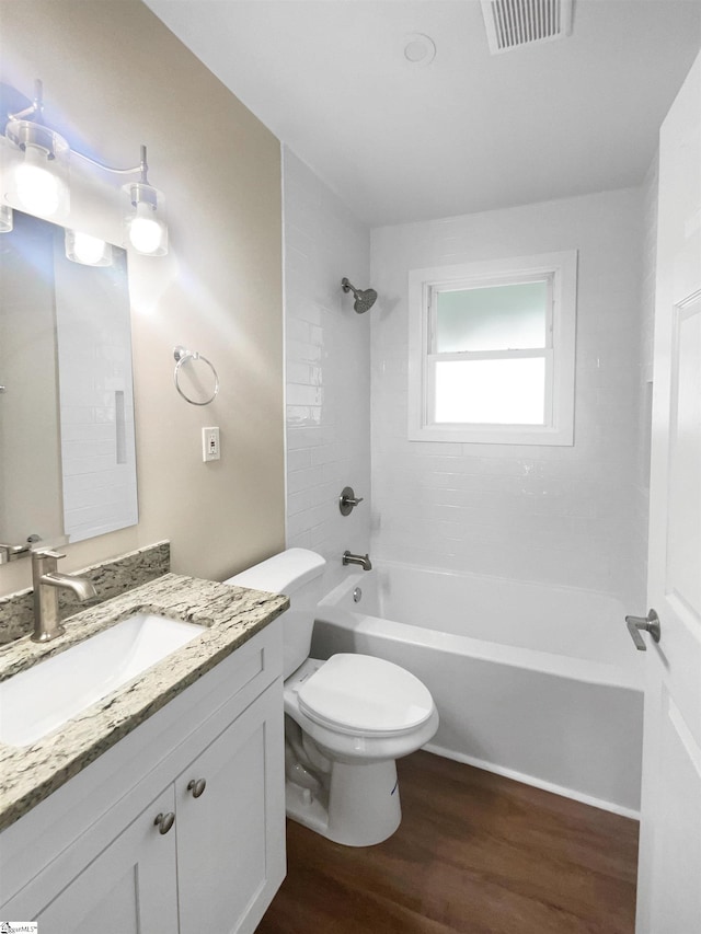 full bathroom featuring wood-type flooring, vanity, toilet, and tiled shower / bath