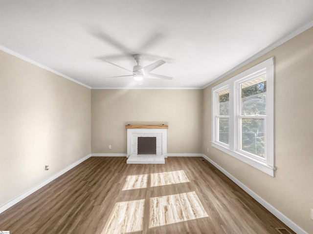 unfurnished living room featuring ceiling fan, light hardwood / wood-style floors, ornamental molding, and a fireplace