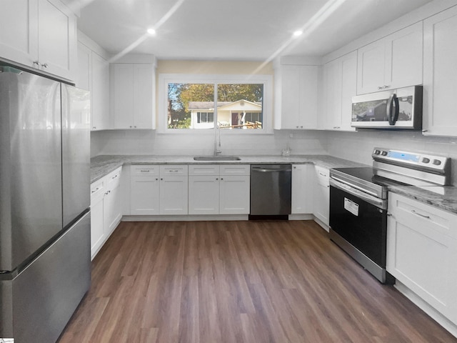 105 Duncan Ave, Greer, SC 29651 - kitchen featuring appliances with stainless steel finishes, a sink, white cabinetry, dark wood-style flooring, and decorative backsplash