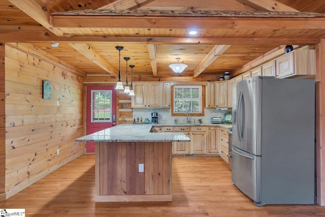 kitchen featuring plenty of natural light, light wood-type flooring, stainless steel fridge with ice dispenser, and wooden walls