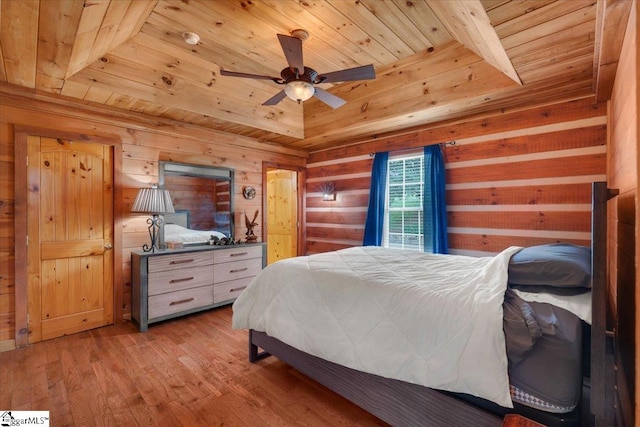 bedroom with light wood-type flooring, wooden walls, ceiling fan, and wooden ceiling