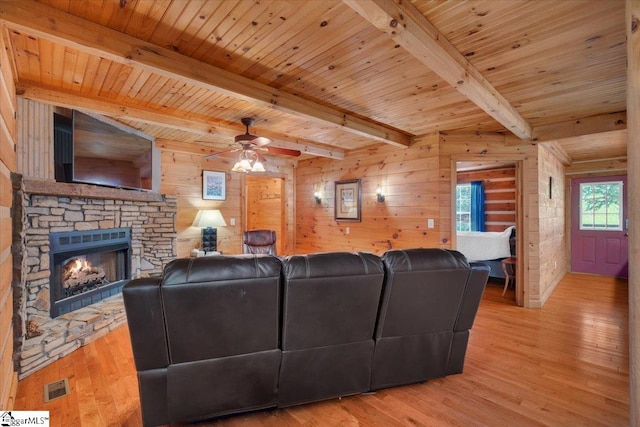 living room with beamed ceiling, light wood-type flooring, wooden ceiling, and wood walls