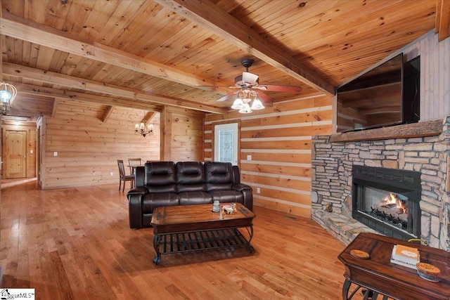 living room with light wood-type flooring, a fireplace, wooden walls, wooden ceiling, and beamed ceiling