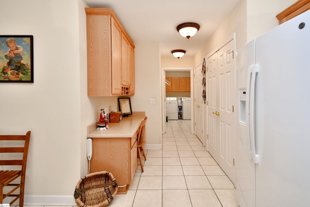 corridor with light tile patterned floors and separate washer and dryer