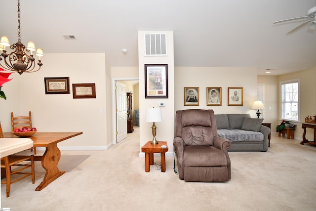 living room with light colored carpet and ceiling fan with notable chandelier