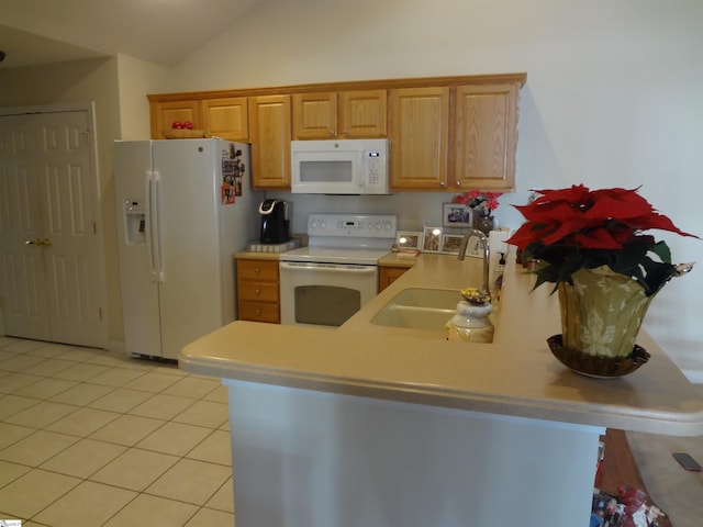 kitchen with lofted ceiling, white appliances, sink, light tile patterned floors, and kitchen peninsula