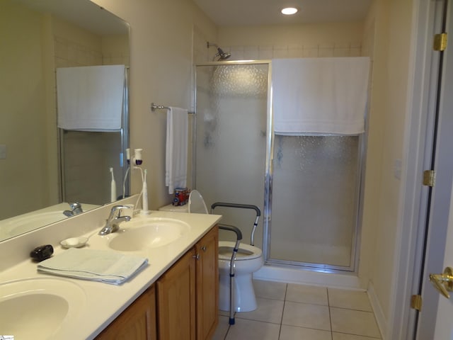 bathroom featuring tile patterned flooring, vanity, toilet, and a shower with shower door