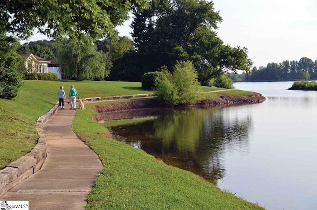 view of community featuring a lawn and a water view