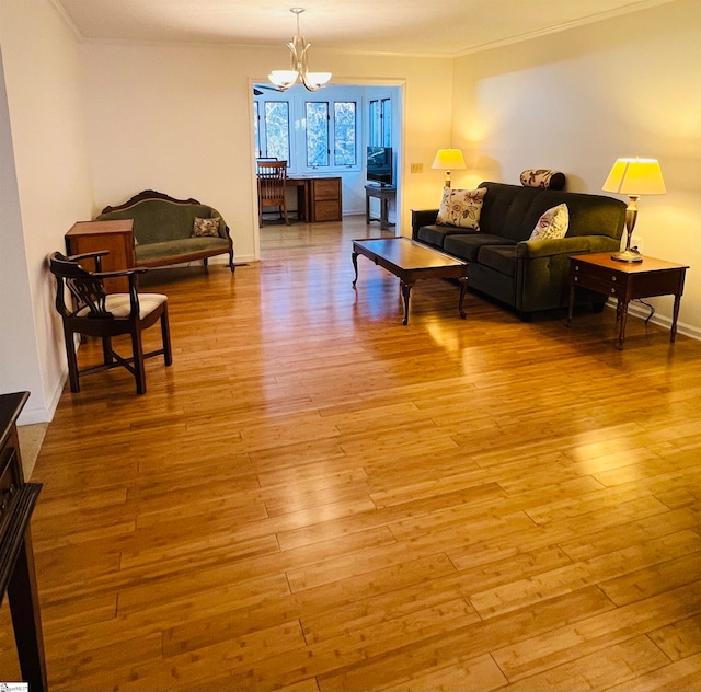 living room featuring a chandelier, light wood-type flooring, and ornamental molding