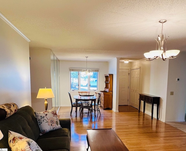 living room featuring a chandelier, a textured ceiling, and hardwood / wood-style flooring