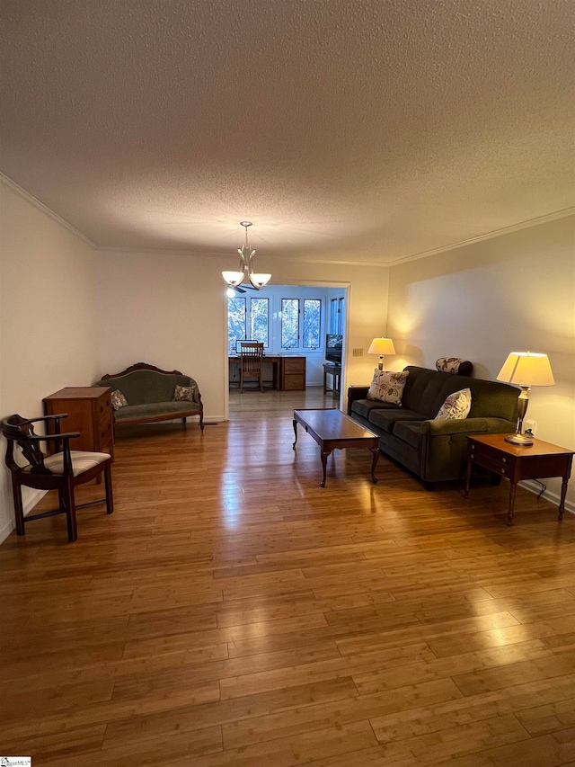 living room with crown molding, a chandelier, a textured ceiling, and hardwood / wood-style flooring