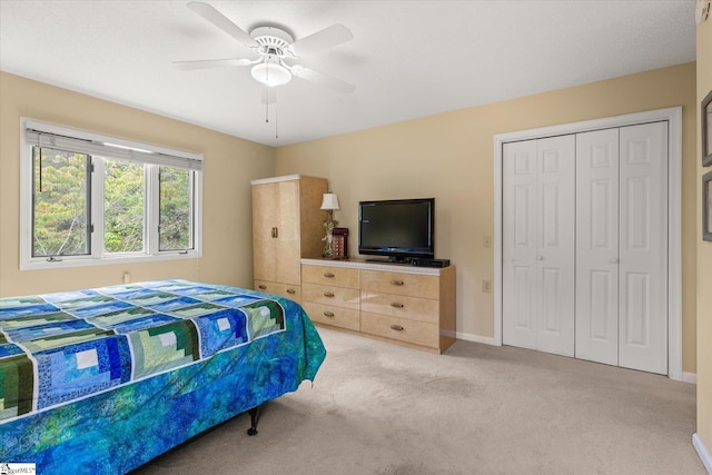 carpeted bedroom featuring ceiling fan and a closet