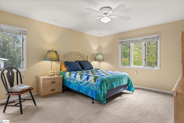 bedroom with ceiling fan and light carpet