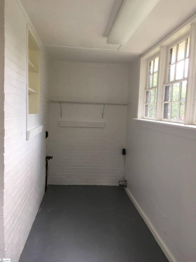 laundry room featuring brick wall