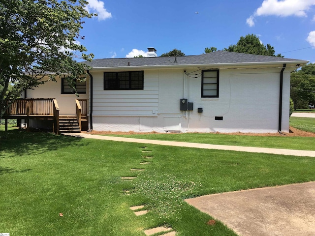 view of front facade with a front yard and a wooden deck