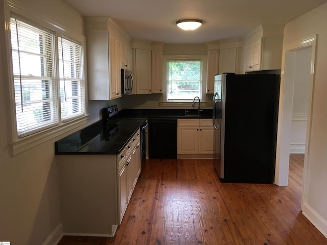 kitchen with black appliances, dark hardwood / wood-style floors, white cabinetry, and sink