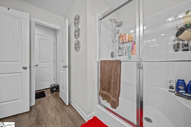 bathroom featuring hardwood / wood-style flooring and an enclosed shower