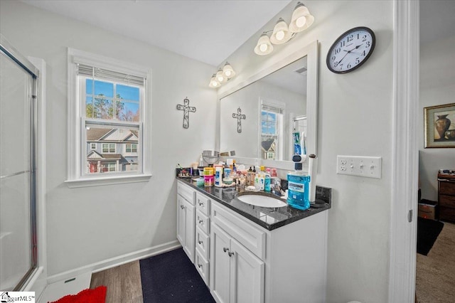 bathroom with hardwood / wood-style floors, vanity, and a shower with door