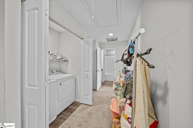 clothes washing area featuring hardwood / wood-style flooring and washer and clothes dryer