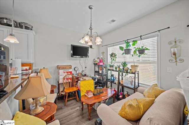 living room with hardwood / wood-style floors and a notable chandelier