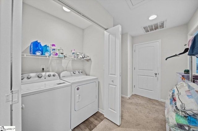 clothes washing area featuring washer and clothes dryer and light carpet