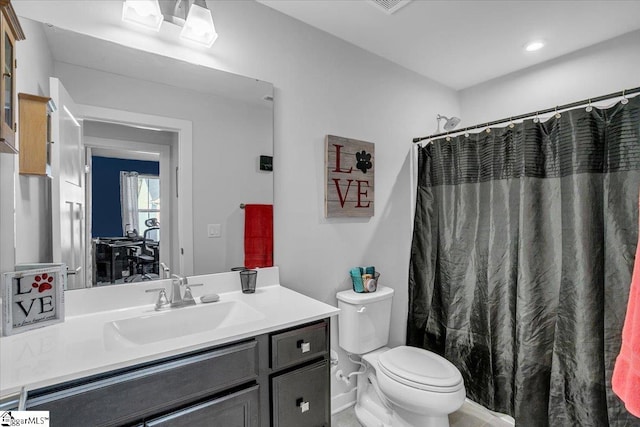 bathroom featuring a shower with shower curtain, vanity, and toilet