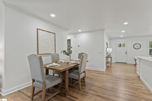 dining room featuring crown molding and light hardwood / wood-style floors