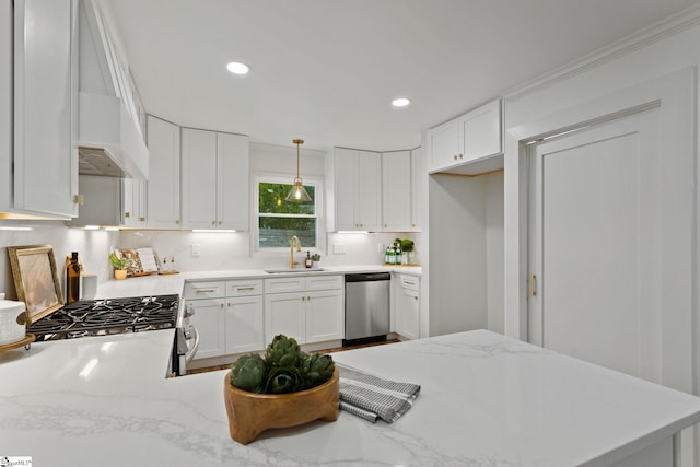 kitchen with white cabinetry, sink, hanging light fixtures, decorative backsplash, and appliances with stainless steel finishes