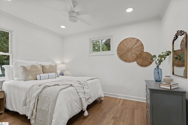 bedroom with wood-type flooring, multiple windows, crown molding, and ceiling fan