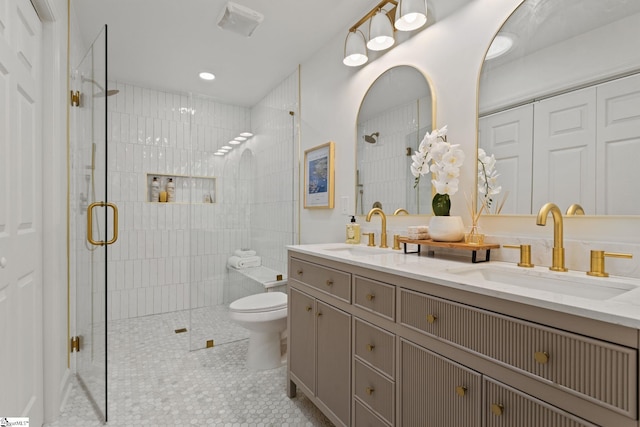 bathroom featuring tile patterned flooring, vanity, toilet, and a shower with door