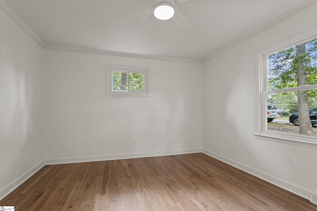 empty room featuring hardwood / wood-style flooring, a wealth of natural light, and ornamental molding