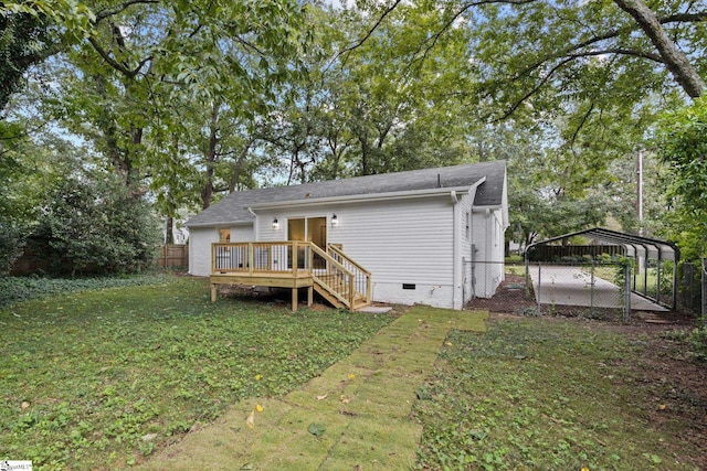 rear view of property featuring a wooden deck, a yard, and a carport