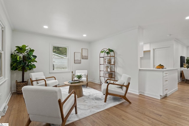 sitting room with light hardwood / wood-style floors and ornamental molding