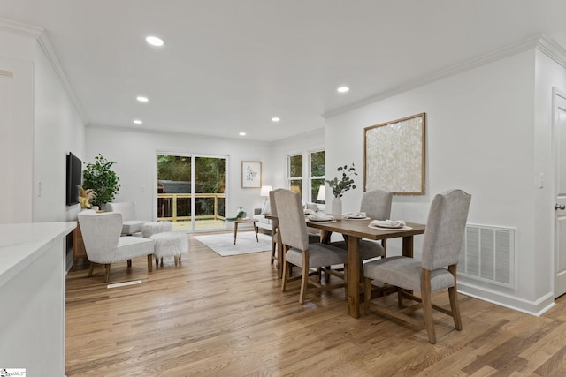 dining room with light hardwood / wood-style flooring and ornamental molding