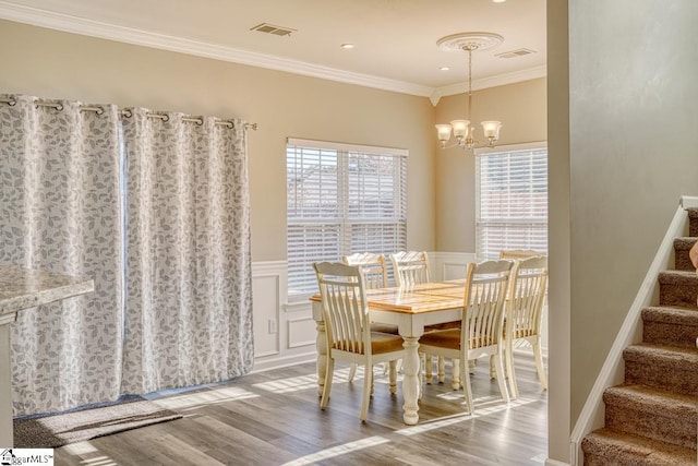 dining room featuring a chandelier, wood-type flooring, and ornamental molding