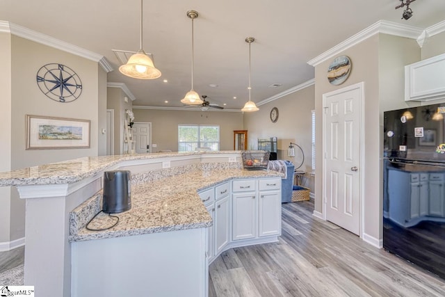 kitchen featuring light wood-type flooring, white cabinetry, ceiling fan, and ornamental molding