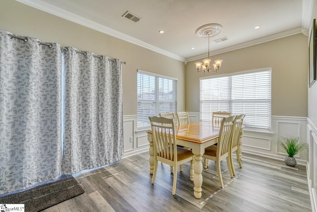 dining area featuring a chandelier, crown molding, and light hardwood / wood-style flooring