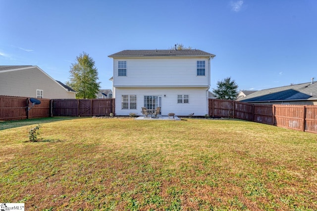 rear view of house featuring a lawn and a patio