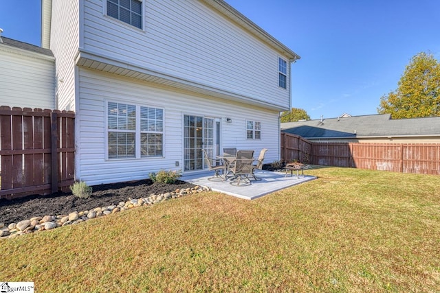 rear view of property featuring a yard and a patio area