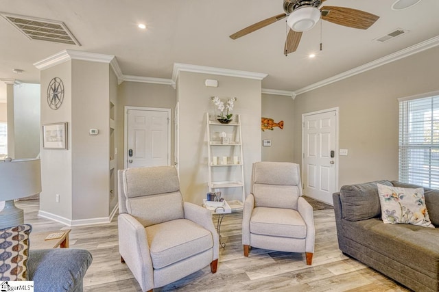 living room featuring light hardwood / wood-style floors, ceiling fan, and ornamental molding