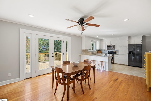 dining space featuring french doors, light wood-type flooring, and ornamental molding