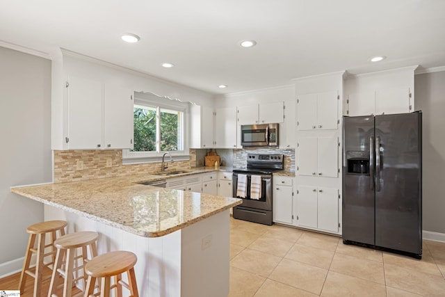 kitchen with white cabinets, crown molding, sink, appliances with stainless steel finishes, and light stone counters