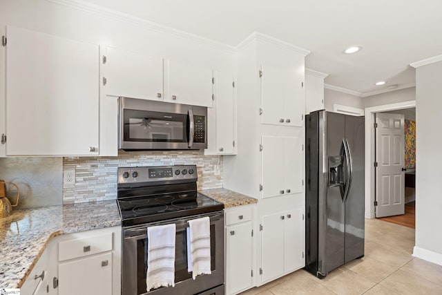 kitchen with white cabinets, stainless steel appliances, light stone counters, and ornamental molding